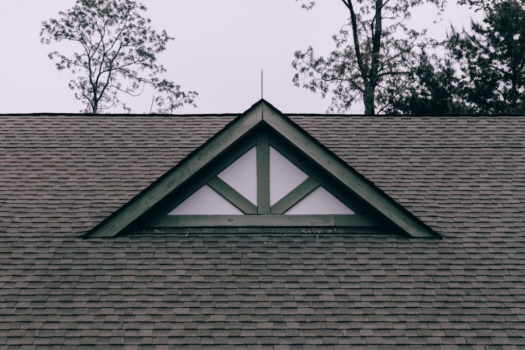 Grey residential roof with shingles and architectural detail